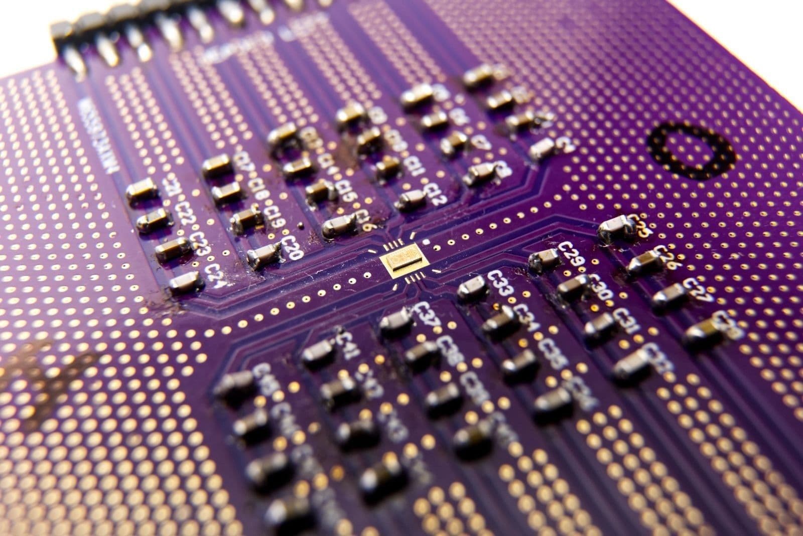 Macro of a custom Falcomm RF board with a bare die wire-bonded at its center