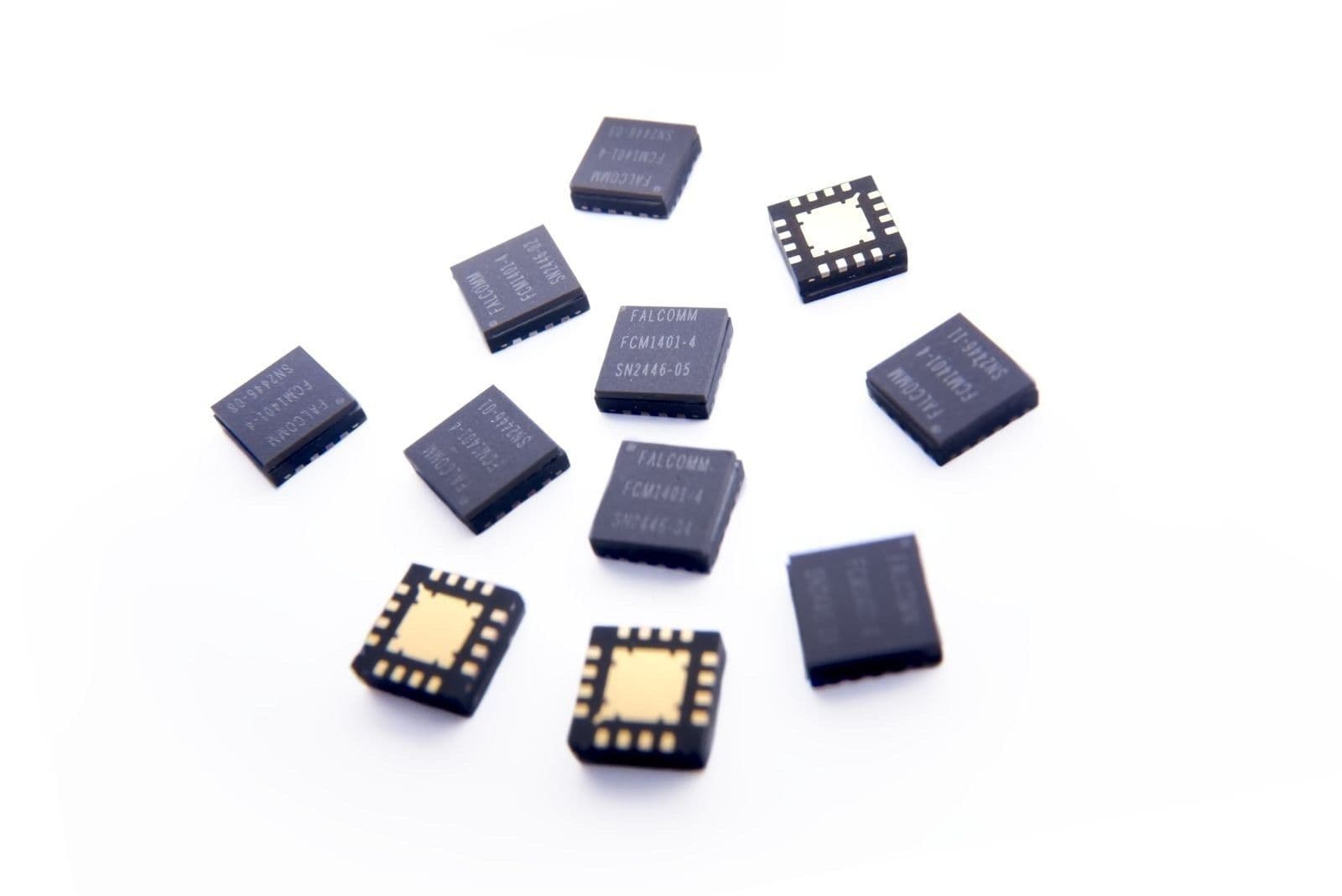 Laser-marked Falcomm QFN packages, some flipped to show the exposed pad and lead frame